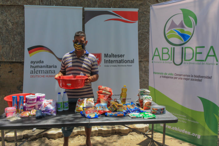 Abiudea and Malteser International Americas giving out a care package with non-perishable food items and hygiene kits to families.