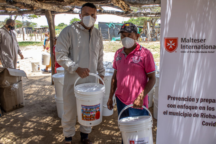 A Malteser International Americas staff member standing with a beneficiary from Colombia.