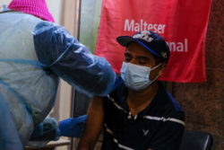 A man getting a flu shot from the Malteser International Americas mobile flu clinic