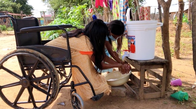 Woman in a wheelchair and her daughter getting water. 